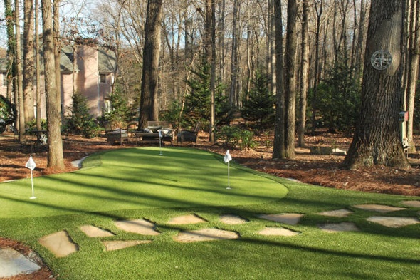 Augusta backyard putting green with flags and trees